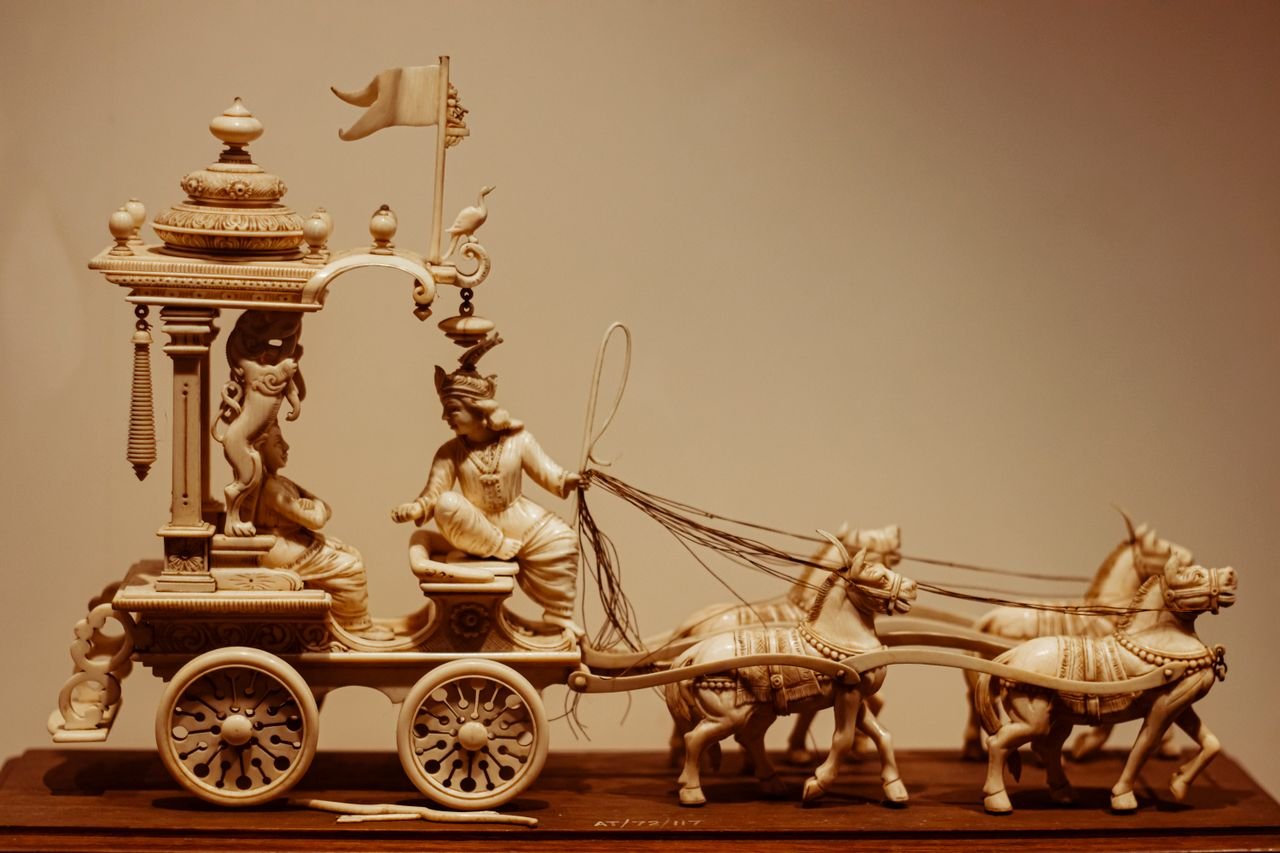 hero-img-01 Detailed ivory chariot figurine, showcasing craftsmanship and ancient style.